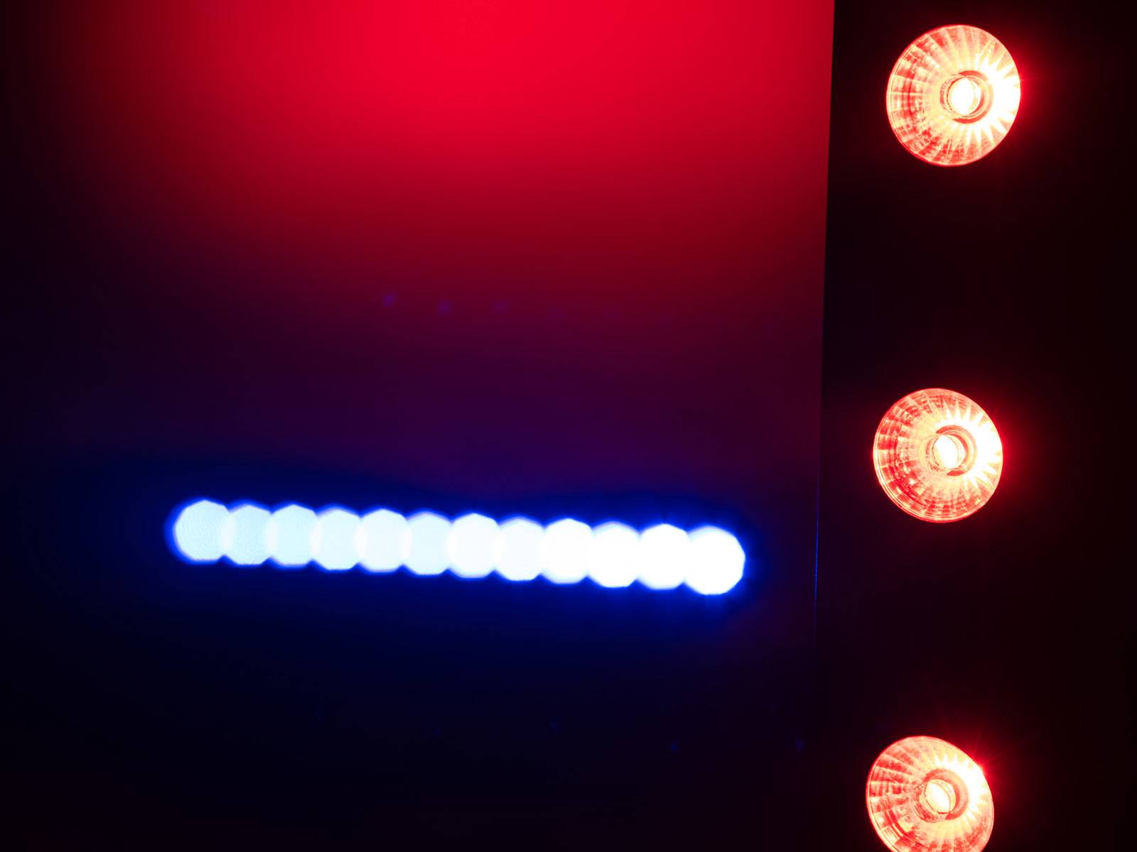 Rote und blaue LED-Lichter in einem dunklen Hintergrund, möglicherweise Teil einer elektronischen Anzeige oder eines Geräts.