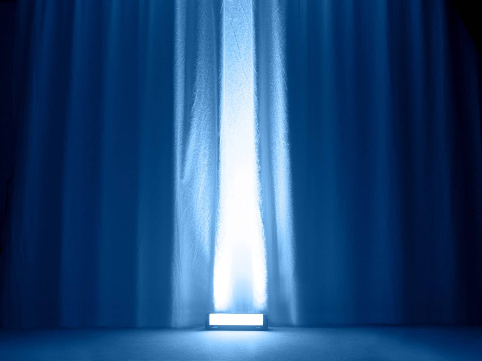 Ein Vorhang wird von einem blauen Lichtstrahl von unten beleuchtet, der eine dramatische und geheimnisvolle Atmosphäre schafft.