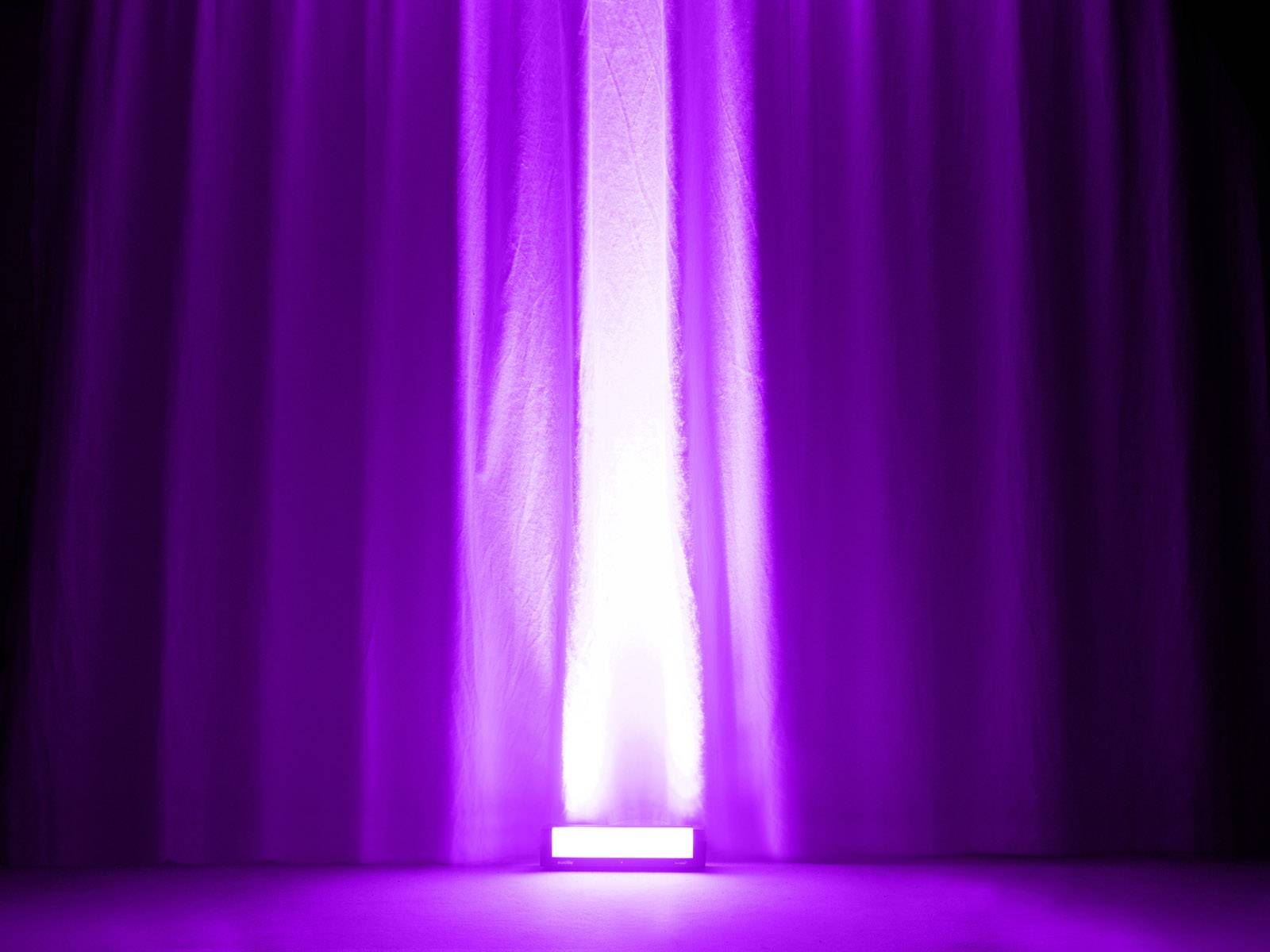 Lila Vorhänge werden von unten lila beleuchtet, wodurch ein dramatischer Effekt entsteht.