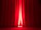 Ein roter Vorhang wird von unten beleuchtet, was eine stimmungsvolle und dramatische Atmosphäre erzeugt.