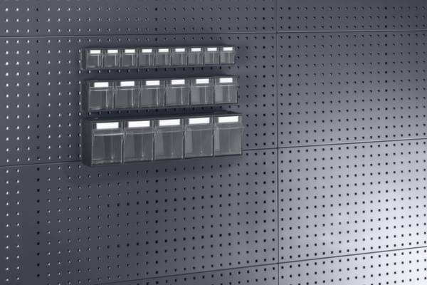 Kleine, transparente Aufbewahrungsboxen an einer grauen Lochwand montiert, nützlich zur ordentlichen Organisation von Kleinteilen.