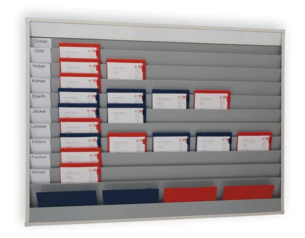 An einem Wandorganizer sind Dokumentenmappen in Rot und Blau eingesteckt. Auf jeder Mappe sind Namensschilder sichtbar.