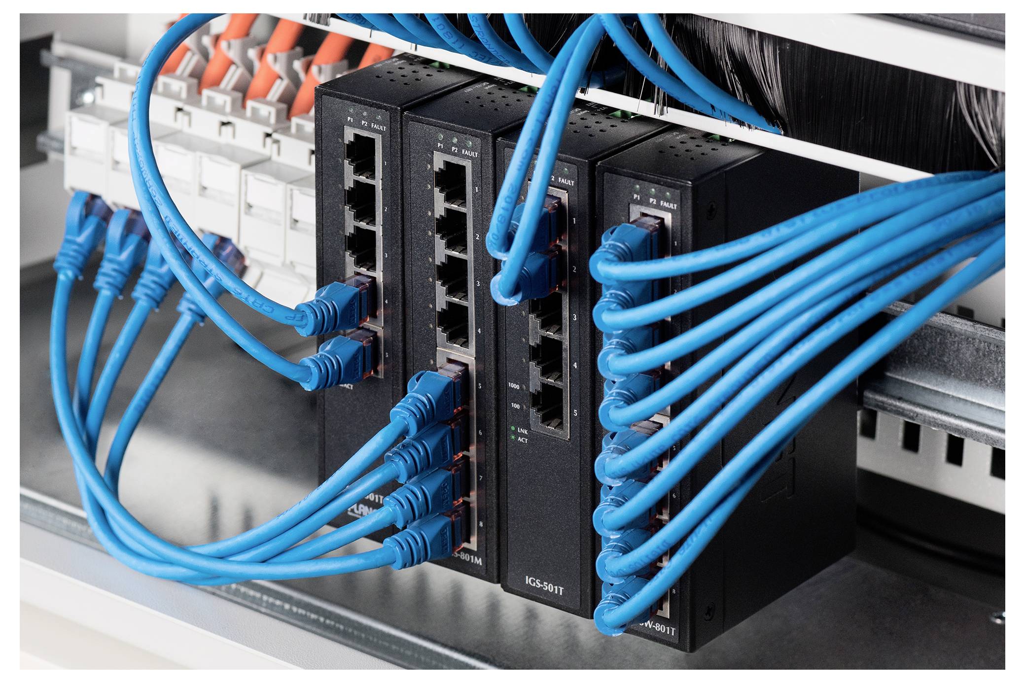 Netzwerk-Switches mit mehreren blauen Ethernet-Kabeln, die aktive Datenleitungen in einer Servergestell-Umgebung anzeigen.