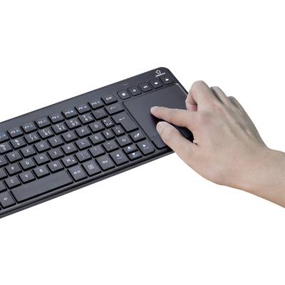 Eine Hand benutzt das Touchpad auf einer drahtlosen Tastatur, die auf einer weißen Oberfläche liegt.