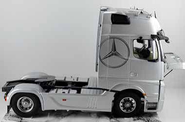 Ein silberner Lkw ohne Anhänger von der Seite. Das Logo eines bekannten Autoherstellers ist auf der Fahrerkabine sichtbar.
