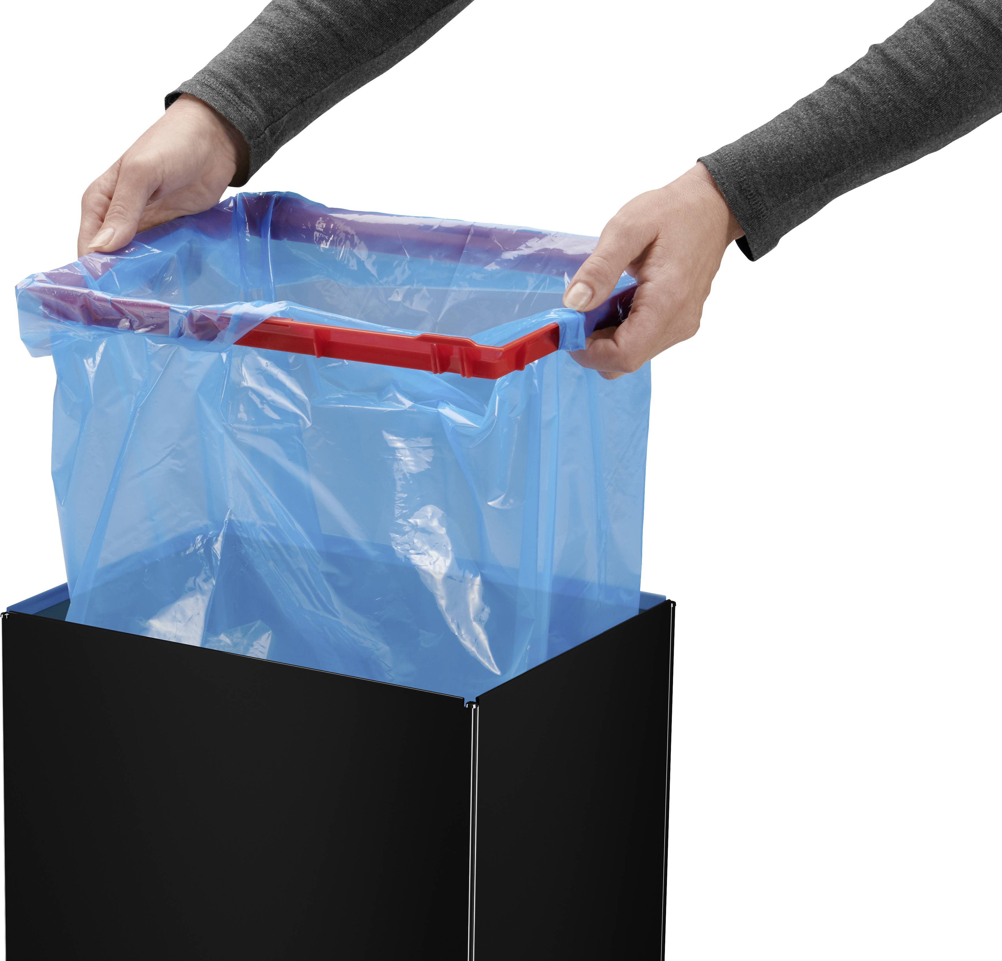 Person zieht einen blauen Müllbeutel über einen schwarzen Mülleimer, indem sie die Ecken des Beutels über den Rand des Eimers stülpt.
