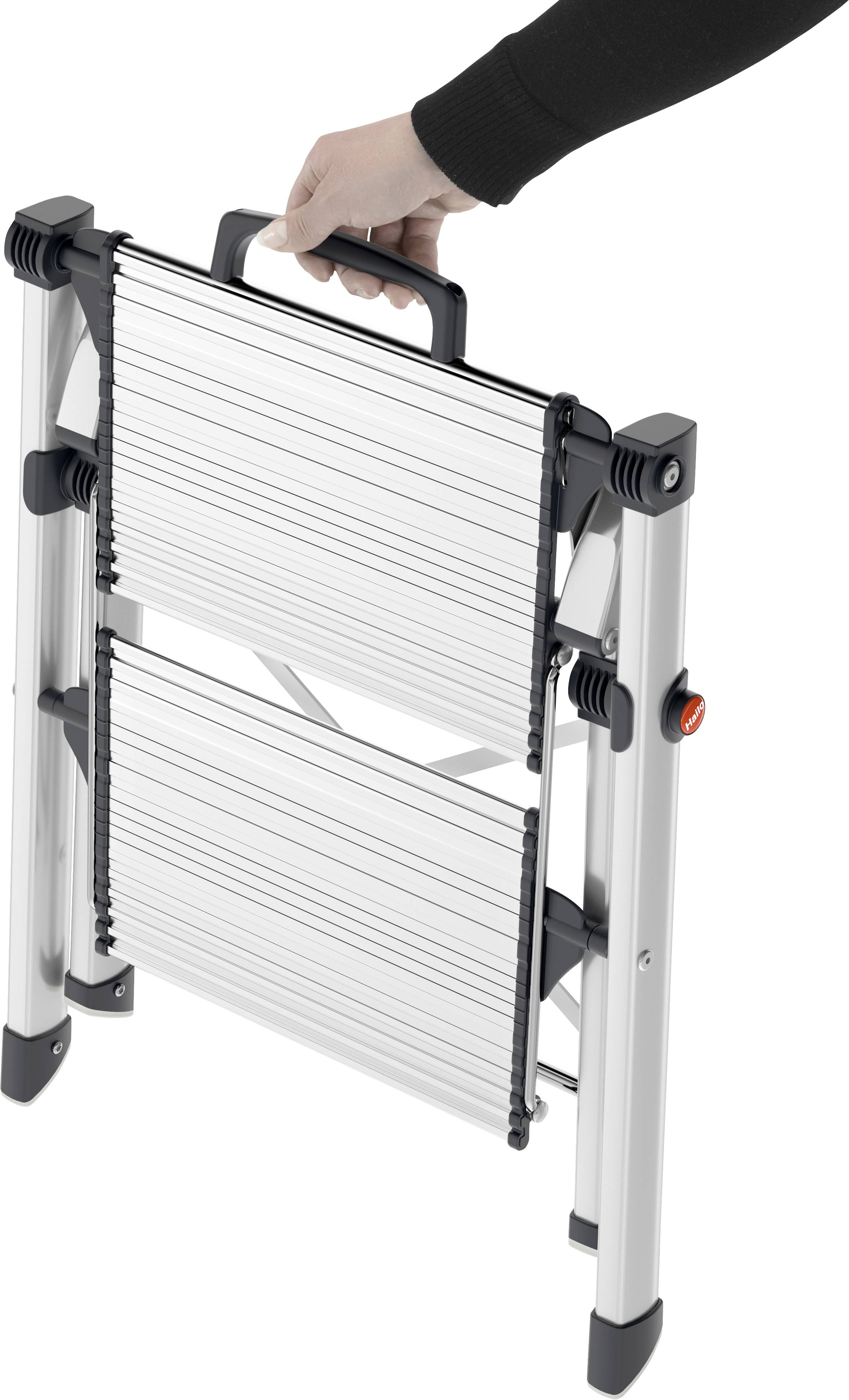 Eine Hand hält eine zusammengeklappte, tragbare Aluminiumleiter am Griff.