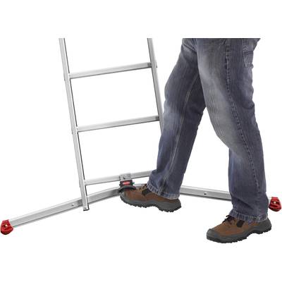Person trägt Jeans und braune Schuhe, steht auf Leiter mit grauem Metallrahmen und roten Gummifüßen.