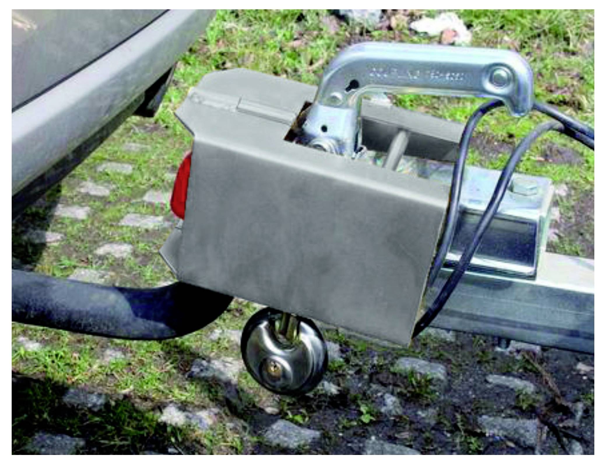 Eine Nahaufnahme der Anhängerkupplung eines Fahrzeugs mit angehängtem Anhänger, die den Kupplungsmechanismus und einen Teil des hinteren Stoßfängers zeigt.