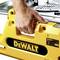 Eine Hand bedient eine gelbe DeWalt Säge, die an einer Tischplatte befestigt ist. Das DeWalt-Logo ist deutlich sichtbar auf der Maschine.
