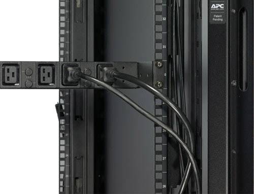 'Rückseite eines Serverracks mit mehreren Stromanschlüssen und Kabeln an einer USV-Einheit befestigt, Herstellername sichtbar.'