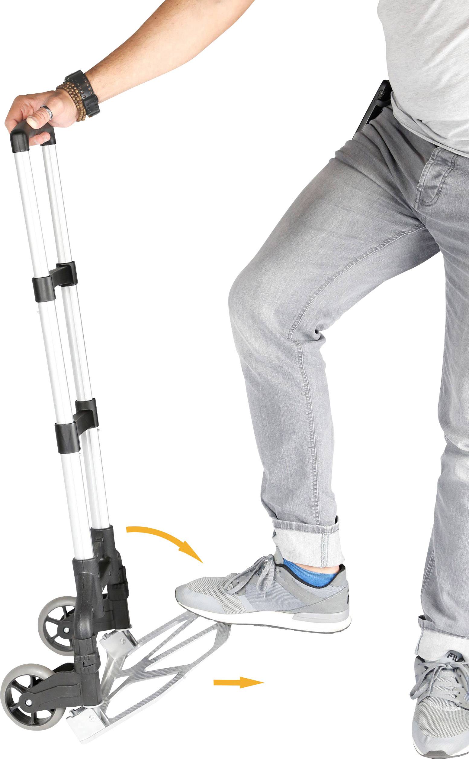 Eine Person benutzt einen zusammenklappbaren Handwagen, indem sie mit einem Fuß das Gestell herunterdrückt.