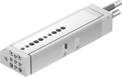 Silberner Zylinder mit mehreren Bohrungen und Anschlüssen, wahrscheinlich ein Bauteil aus der Industrie oder Automatisierungstechnik.
