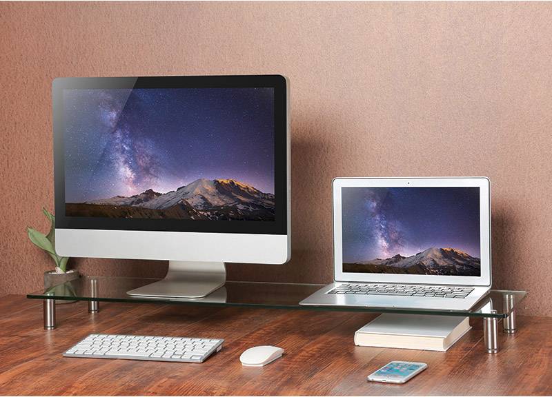 Ein Desktop-Computer und ein Laptop auf einem Schreibtisch zeigen beide ein Weltraum-Hintergrundbild mit Bergen und Sternenhimmel.