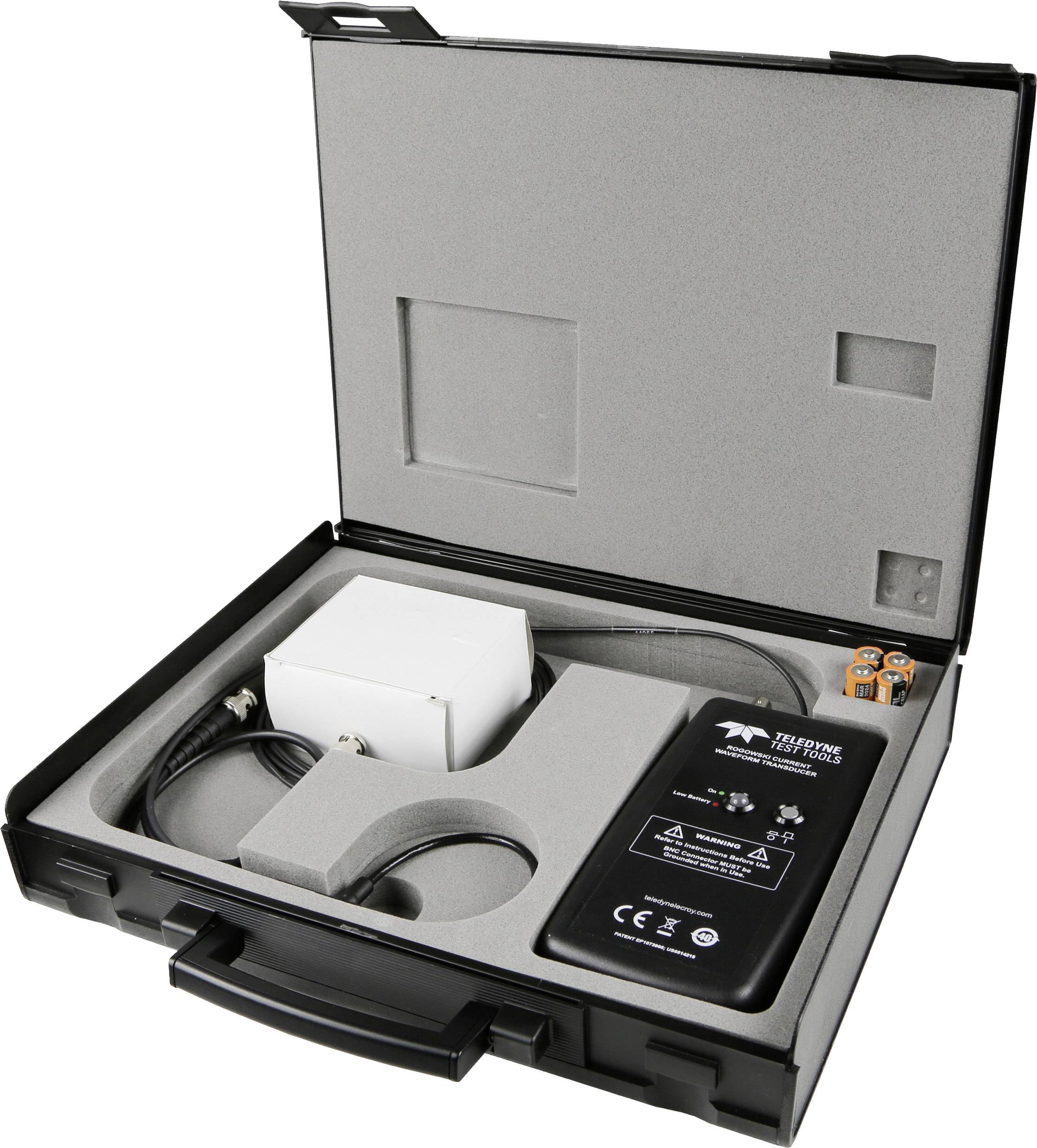 Ein offener schwarzer Koffer enthält ein elektronisches Gerät mit Kabeln und Steckverbindungen, sicher in Schaumstoff eingelegt.