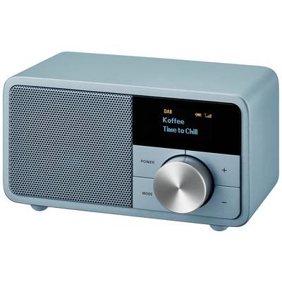 Ein blaues Radio zeigt auf dem Display 'Koffee Time to Chill' an. Links ist ein Lautsprechergitter, rechts ein Drehknopf.