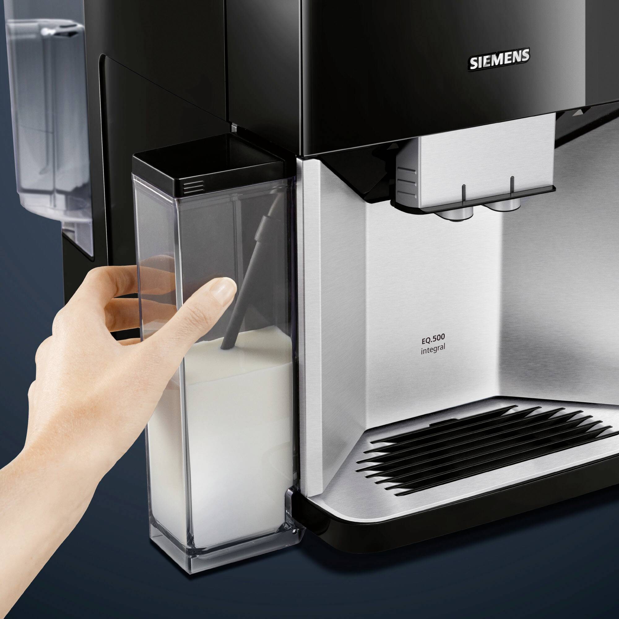 Eine Hand hält einen Milchbehälter, der in eine schwarze Siemens-Kaffeemaschine eingesetzt wird. Links oben steht 'Siemens'.