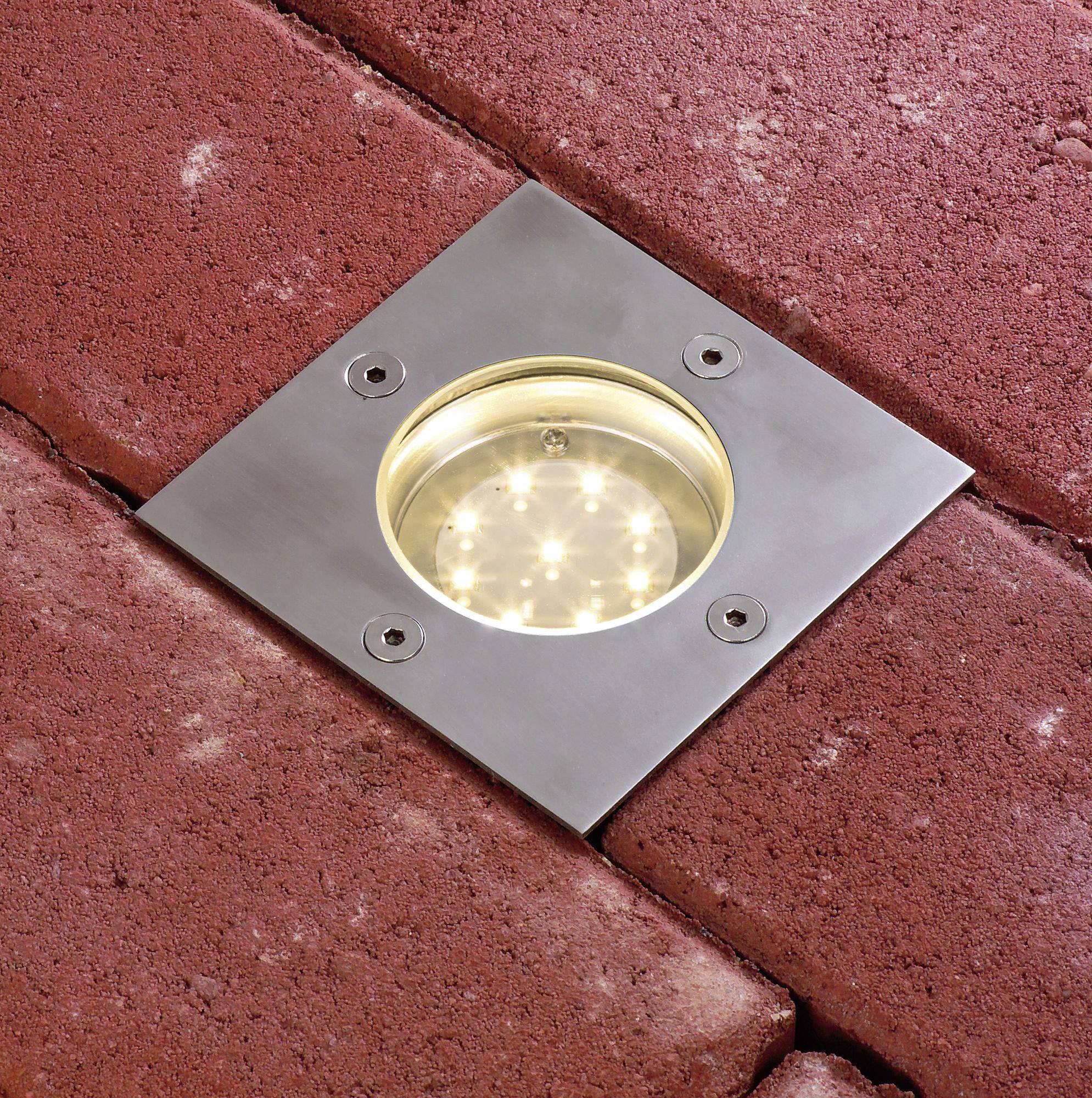 Bodenleuchte in einer gepflasterten Oberfläche integriert, quadratischer Edelstahlrahmen mit kreisförmigem LED-Licht.