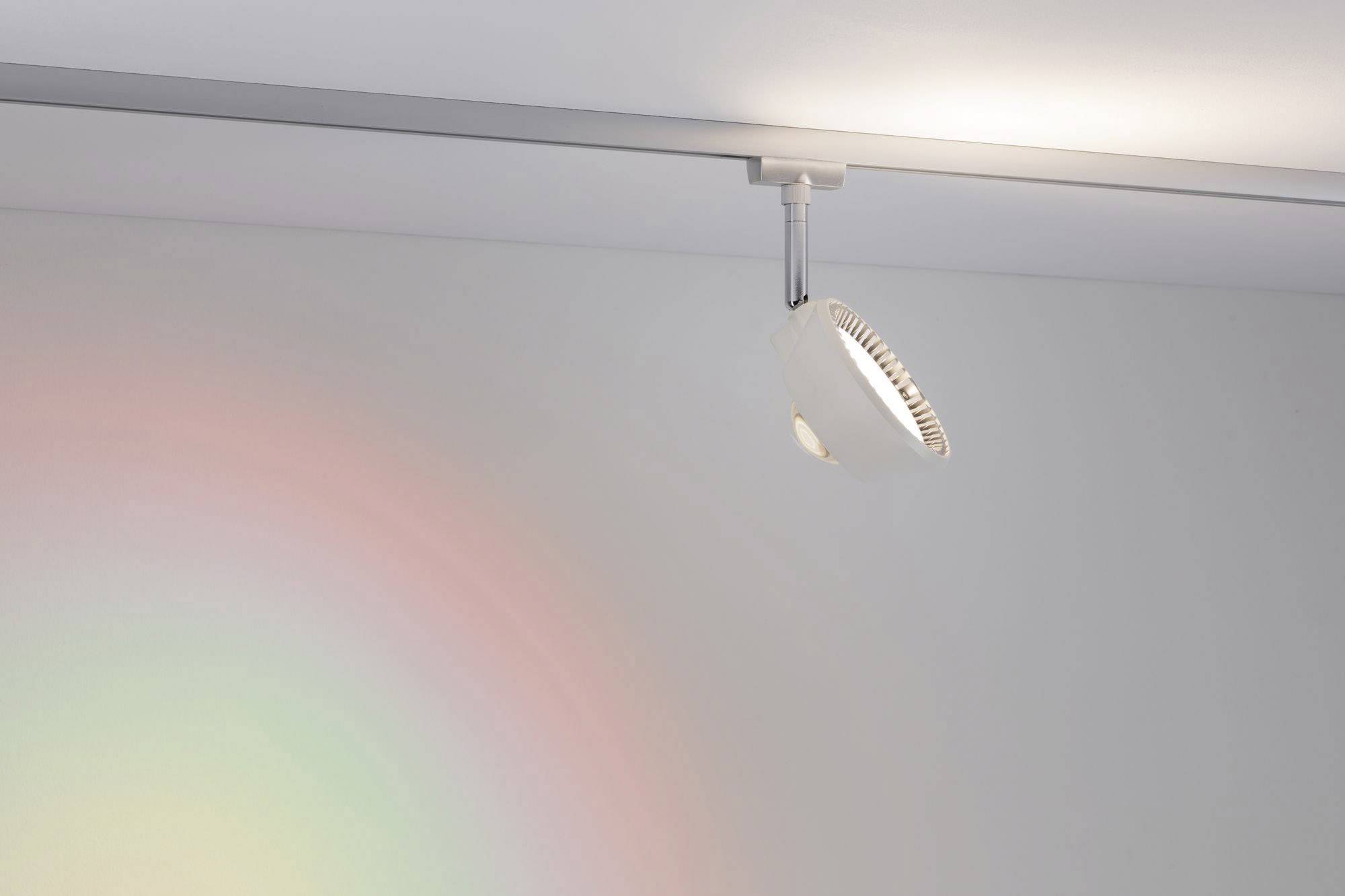 Ein einzelner Scheinwerfer an der Decke erzeugt ein sanftes, mehrfarbiges Lichtmuster auf der Wand.