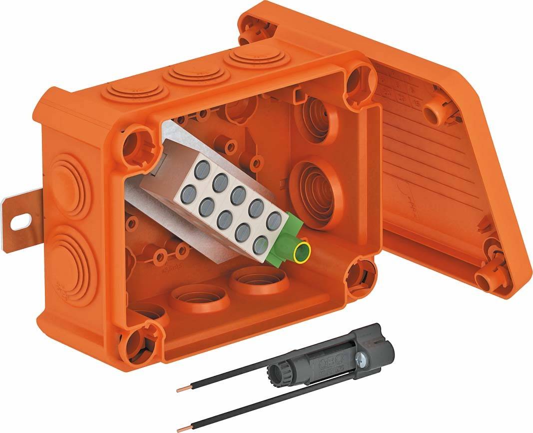 Orange Abzweigdose mit offenem Deckel, innen sichtbare Klemmen und Anschlüsse. Ein Kabelstecker mit zwei Kupferdrähten liegt daneben.