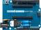 Blaues Entwicklungsboard mit mehreren Anschlussmöglichkeiten, Beschriftung 'MKR2UNO Adapter', enthält elektronische Bauteile.