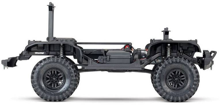 Seitenansicht eines RC-Geländewagen-Chassis ohne Karosserie, mit sichtbaren Federungen, Reifen und zentralem Batteriefach.