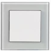 Ein quadratischer, weißer Lichtschalter auf einer gläsernen, quadratischen Abdeckung, vor einem neutralen Hintergrund.