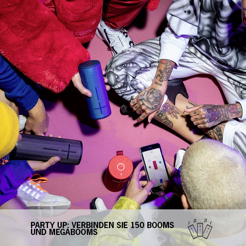 Menschen sitzen im Kreis und halten tragbare Lautsprecher. Eine Person nutzt ein Smartphone. Text: 'Party Up: Verbinden Sie 150 Booms und Megabooms'.