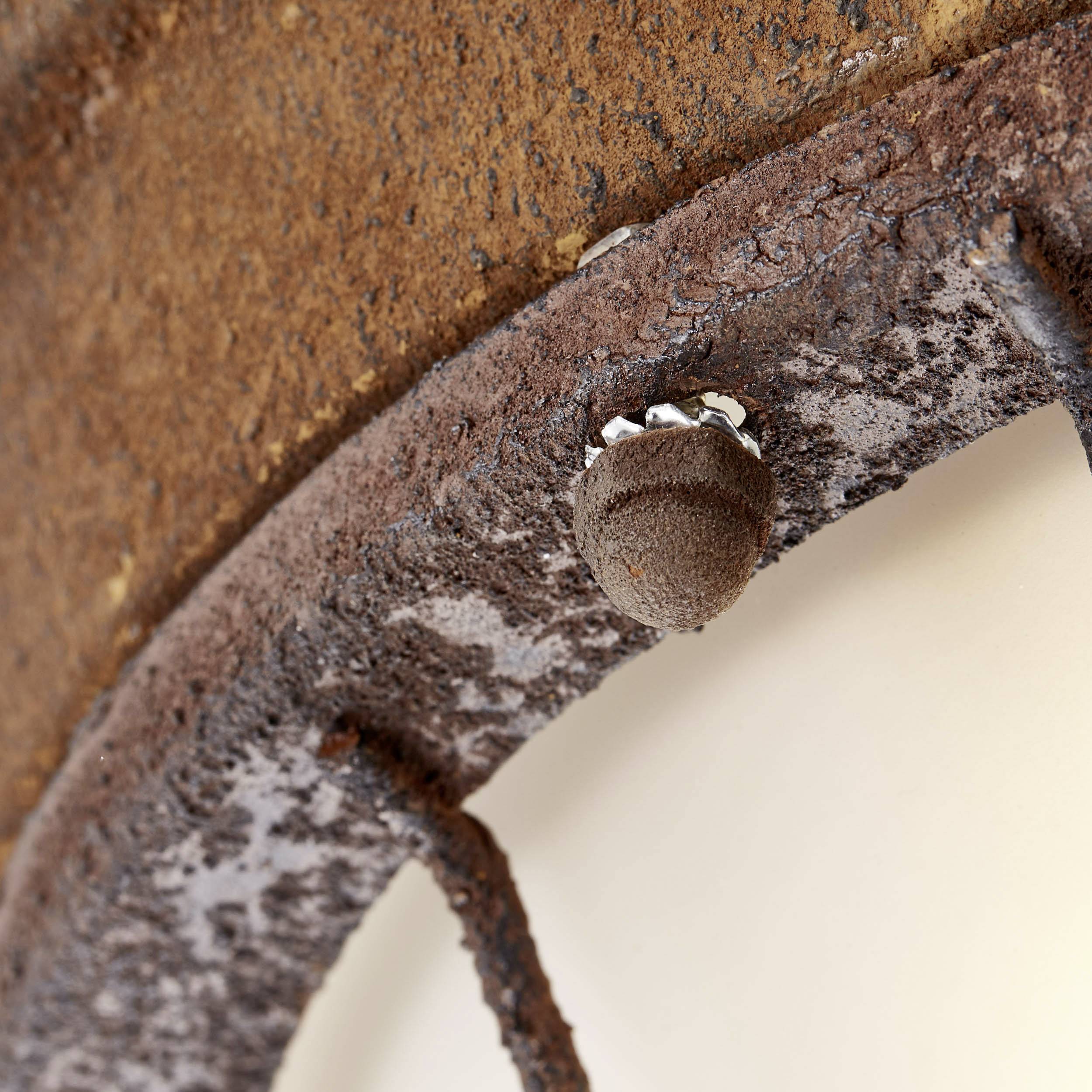 Nahaufnahme eines rostigen Metallstücks mit hervorstehender Sechskantmutter, die die raue Textur und Korrosion des Metalls zeigt.