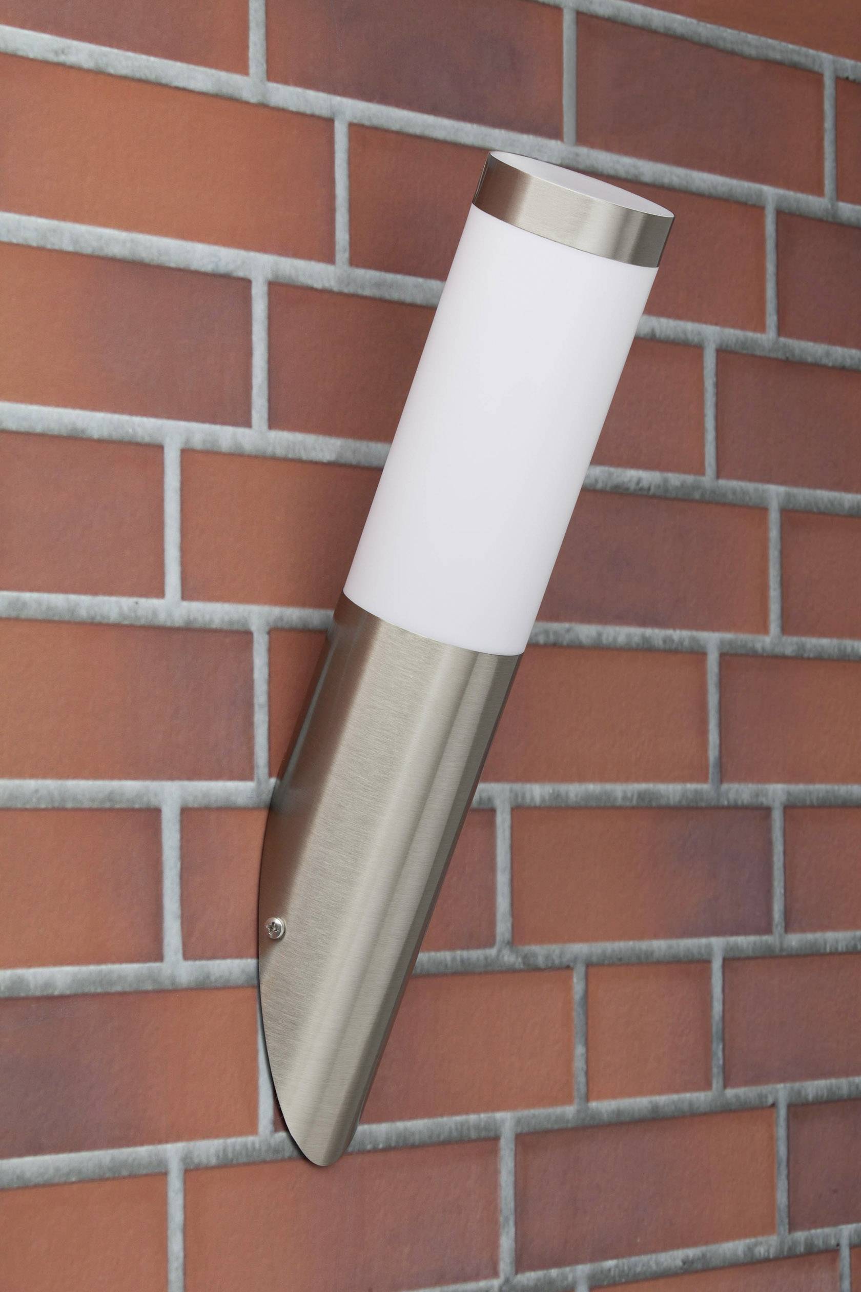Außenwandleuchte in modernem Design mit Edelstahl- und Glaskomponenten, montiert an einer Ziegelwand.