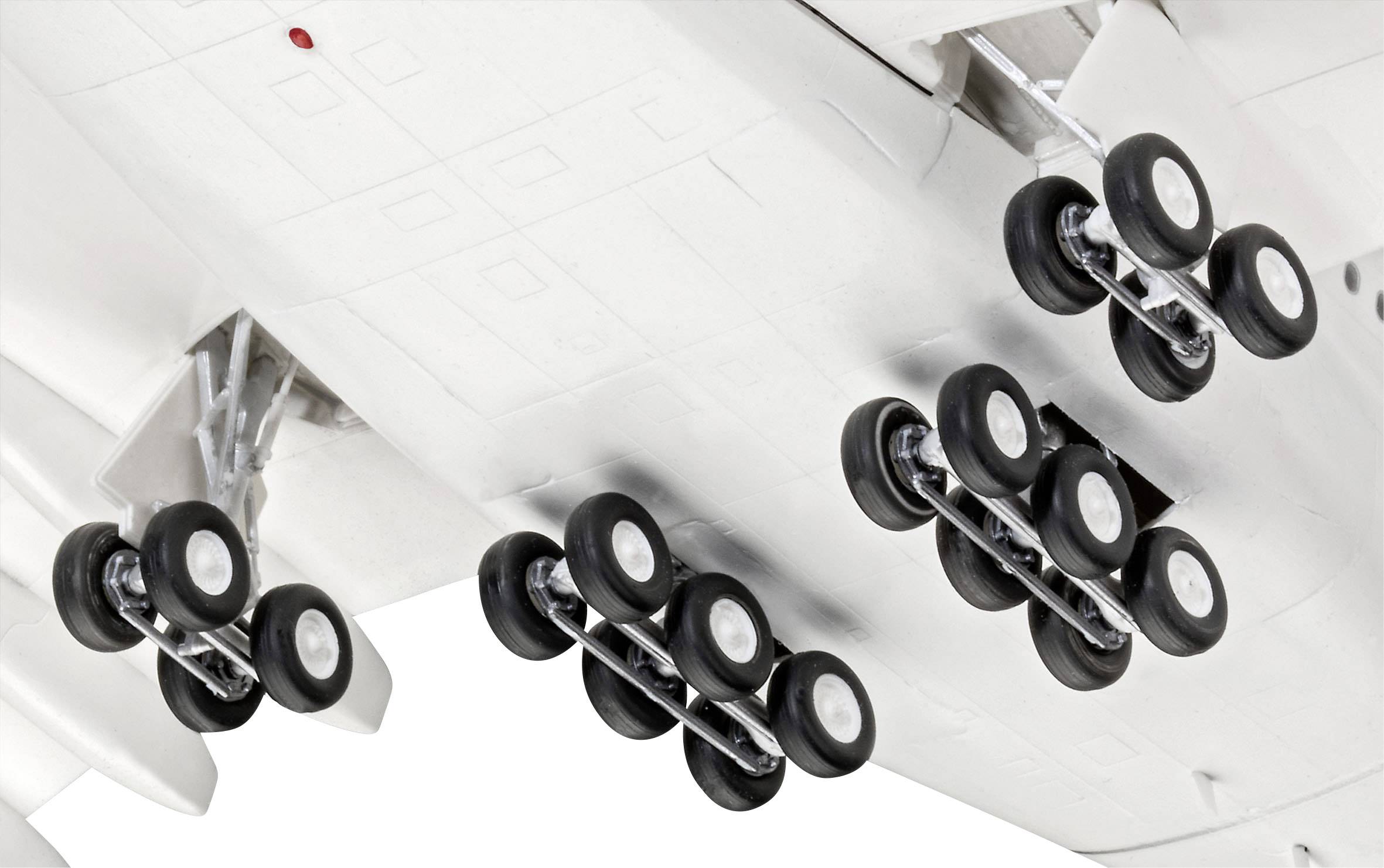 Unterseite eines Flugzeugs mit detaillierter Ansicht des Fahrwerks, das mehrere Reifen aufweist, unterstützt beim Landen und Starten.