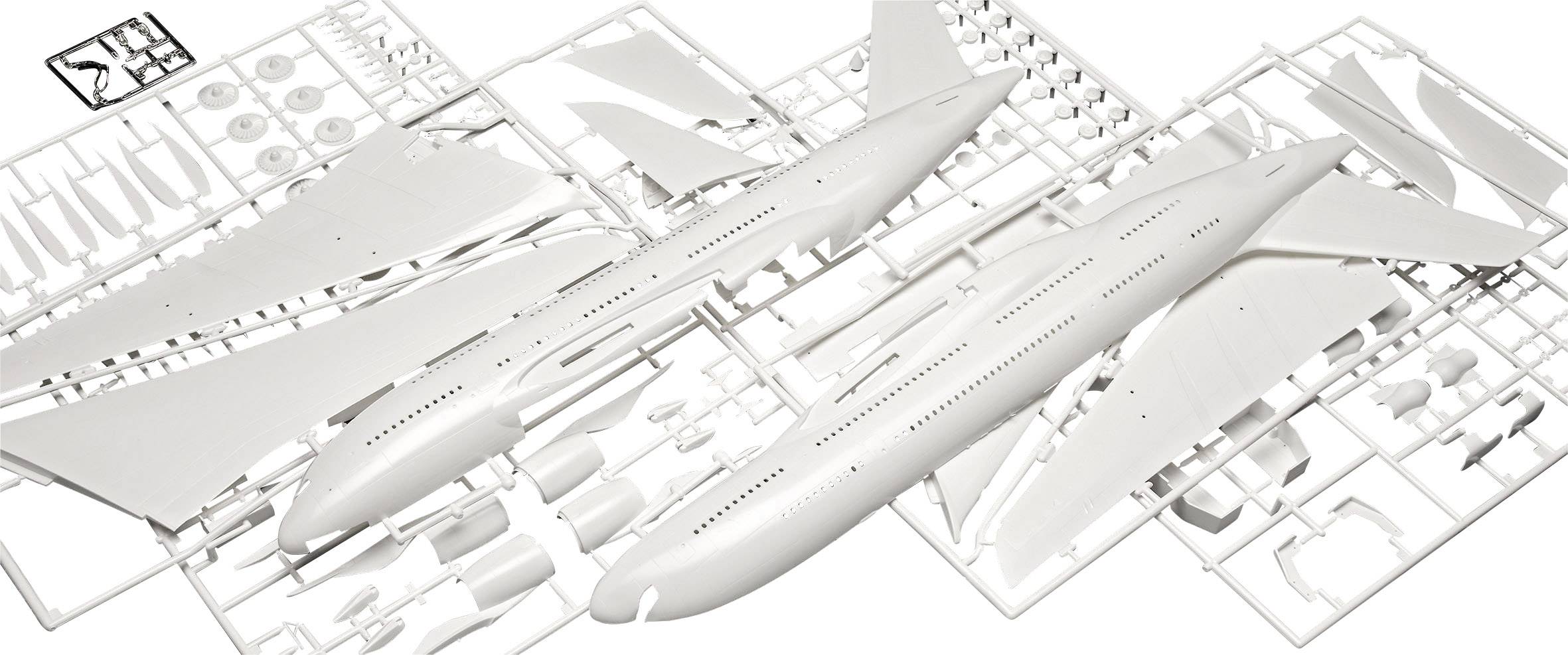 Ein Plastikmodellbausatz eines Flugzeugs zeigt Einzelteile eines Passagierjets zur Montage. Flügel, Rumpf und Räder sind sichtbar.