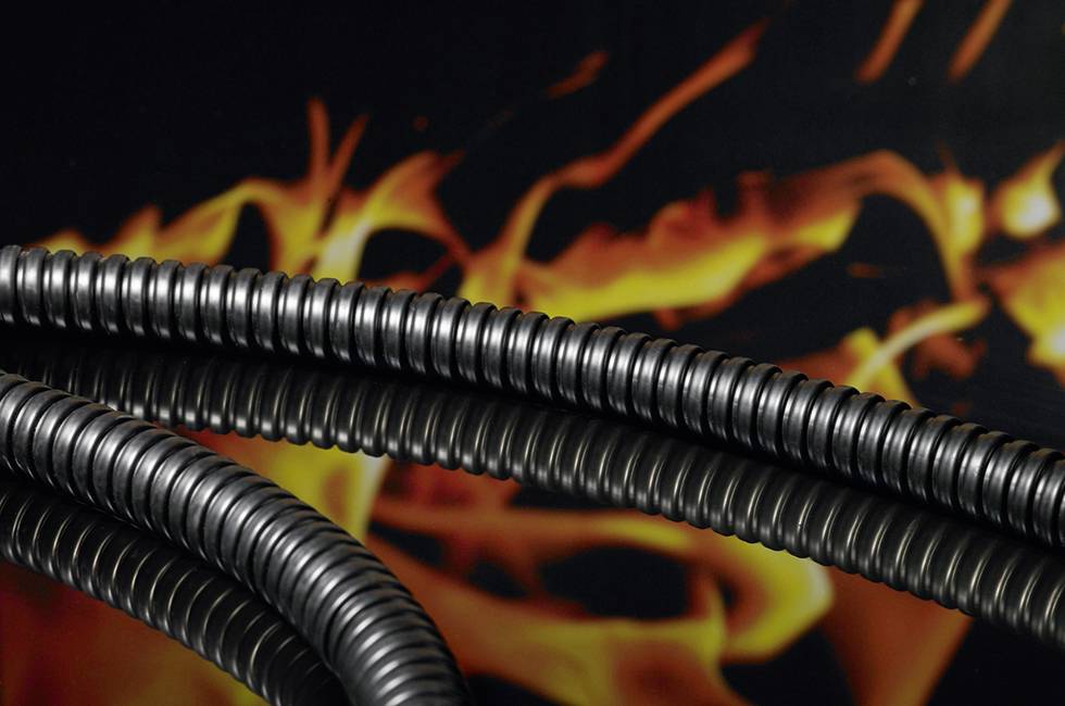 Ein flexibler schwarzer Schlauch- oder Kabelkanal liegt vor einer stilisierten Flammenkulisse, die Robustheit und Widerstandsfähigkeit symbolisiert.