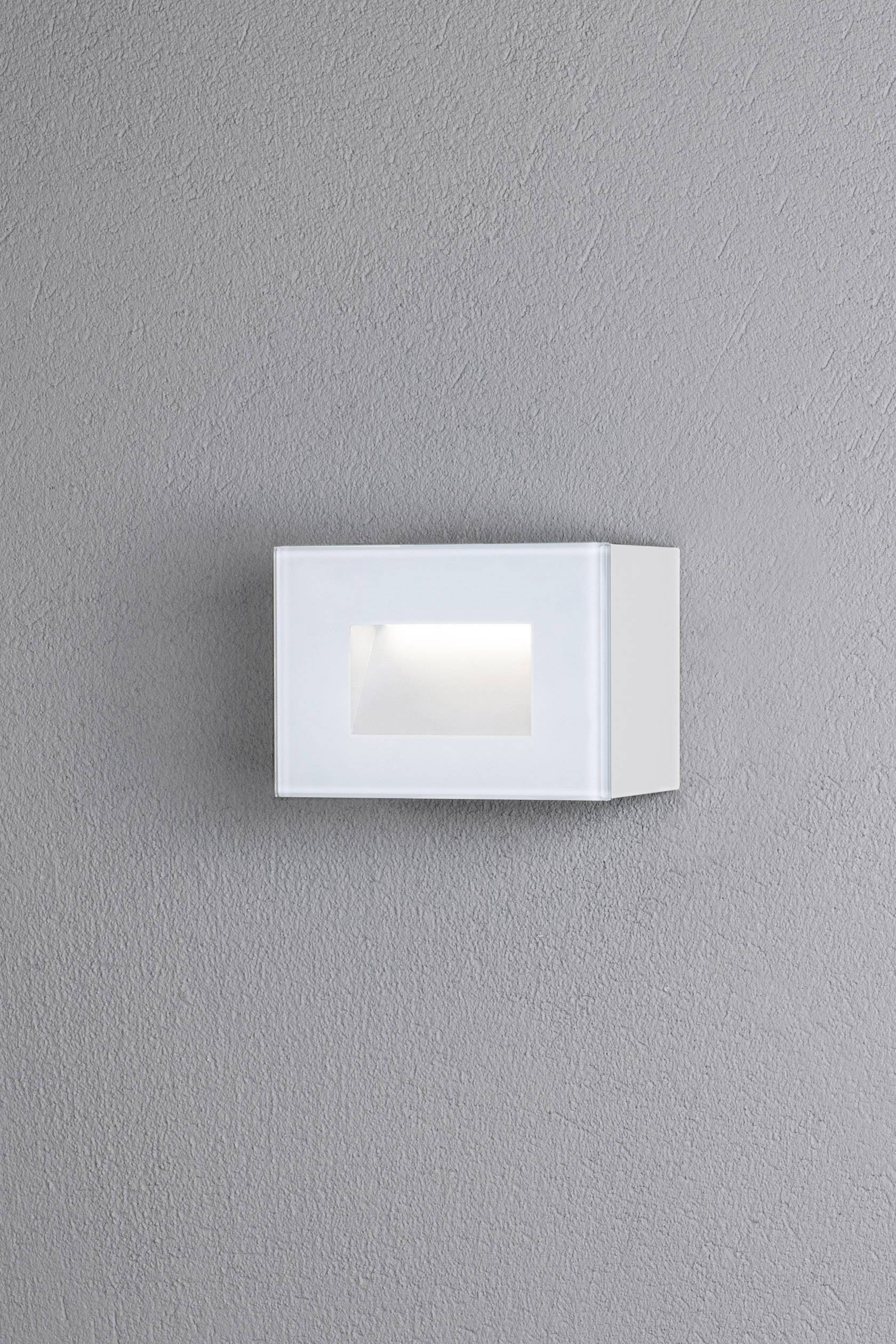 Moderne weiße Wandleuchte an grauer Wand, die diffuses Licht nach unten abstrahlt. Ideal für dezente Raumbeleuchtung.