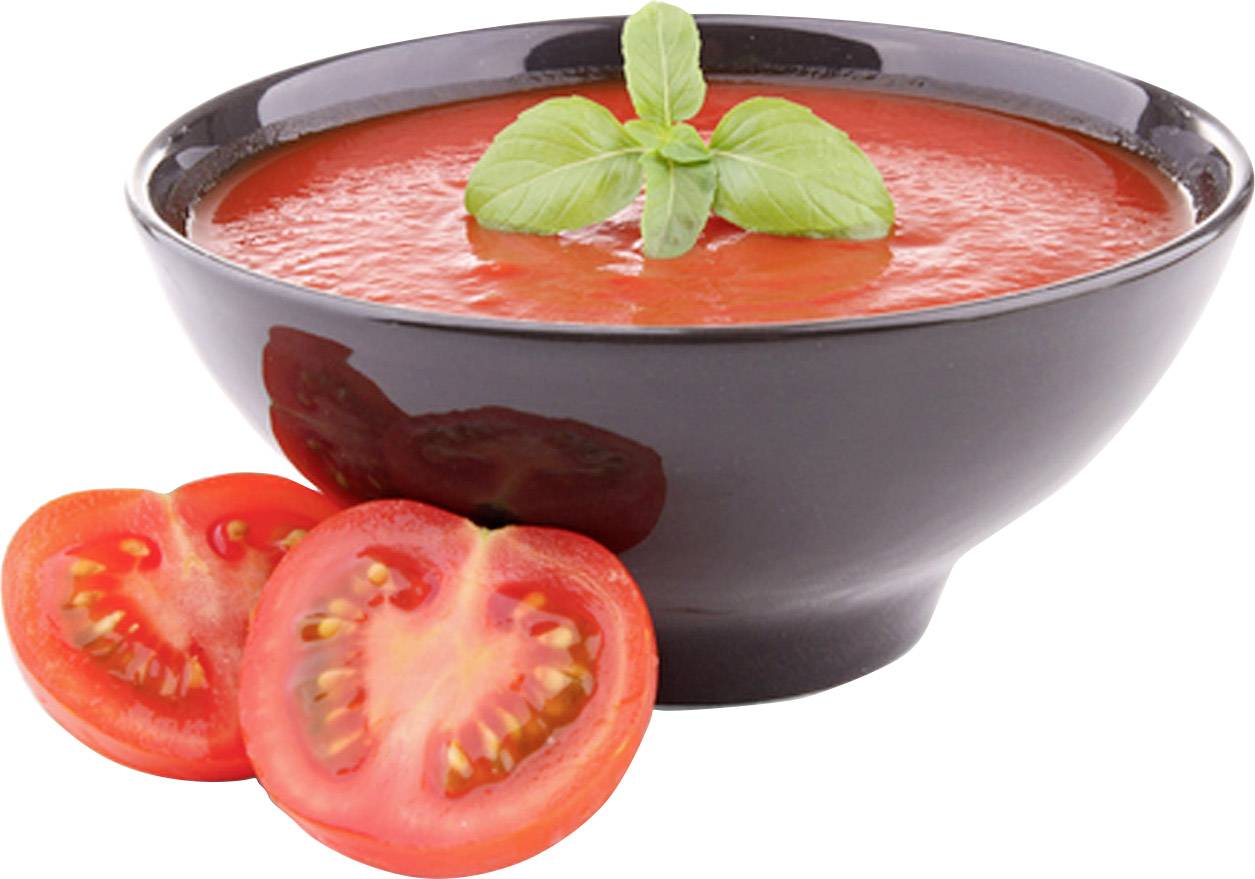 Schüssel mit Tomatensuppe garniert mit Basilikumblättern, daneben zwei halbierte frische Tomaten.