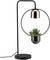 Eine moderne Tischlampe mit rundem, schwarzem Rahmen und kupferfarbenem Lampenschirm; unten ist ein kleiner Pflanzentopf integriert.