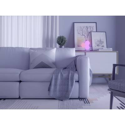 Ein modernes Wohnzimmer mit einem weißen Sofa, einem grauen Überwurf und Kissen, im Hintergrund ein Sideboard mit Kunstwerken.