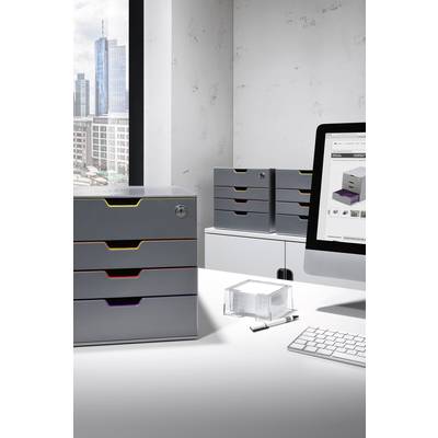 Ein modernes Büro mit Blick auf die Stadt. Auf einem Tisch stehen silberfarbene Schubladenboxen, ein Computer zeigt ein Produktbild.