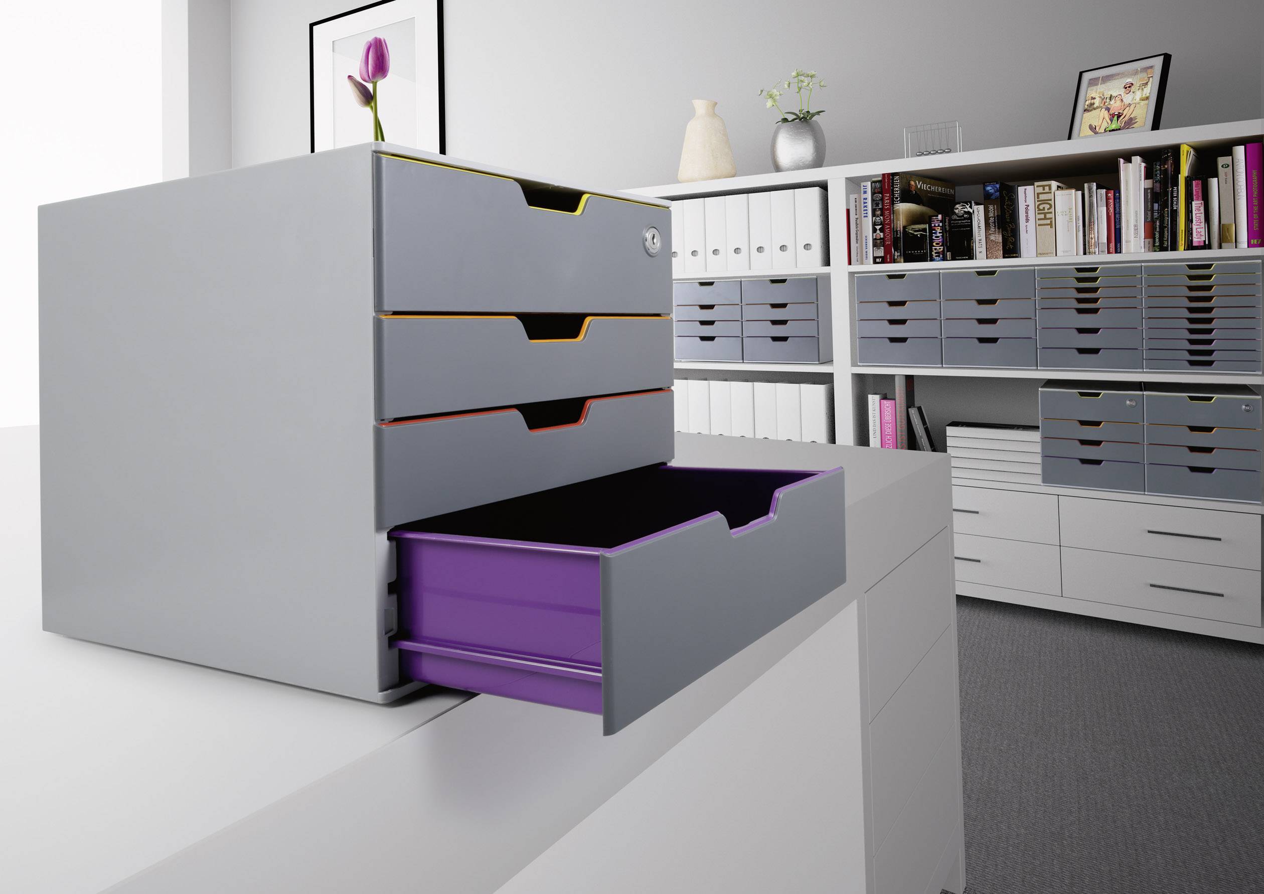 Graues Büro mit offenen Schubladen, eine lila Schublade ist herausgezogen. Bücherregal im Hintergrund.