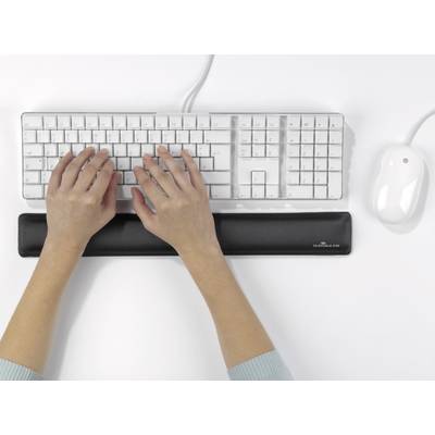 Eine Person tippt auf einer weißen Tastatur mit einer Maus daneben. Eine schwarze Handballenauflage stützt die Hände.