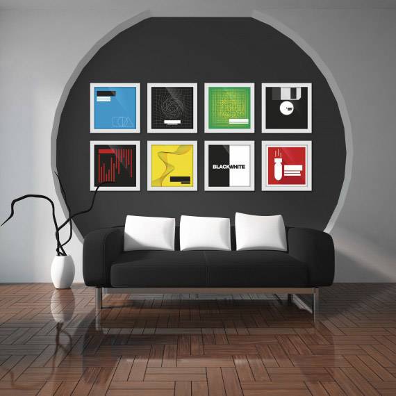 Ein schwarzes Sofa mit weißen Kissen steht vor einer grauen Wand, die mit neun bunten, gerahmten Bildern dekoriert ist.