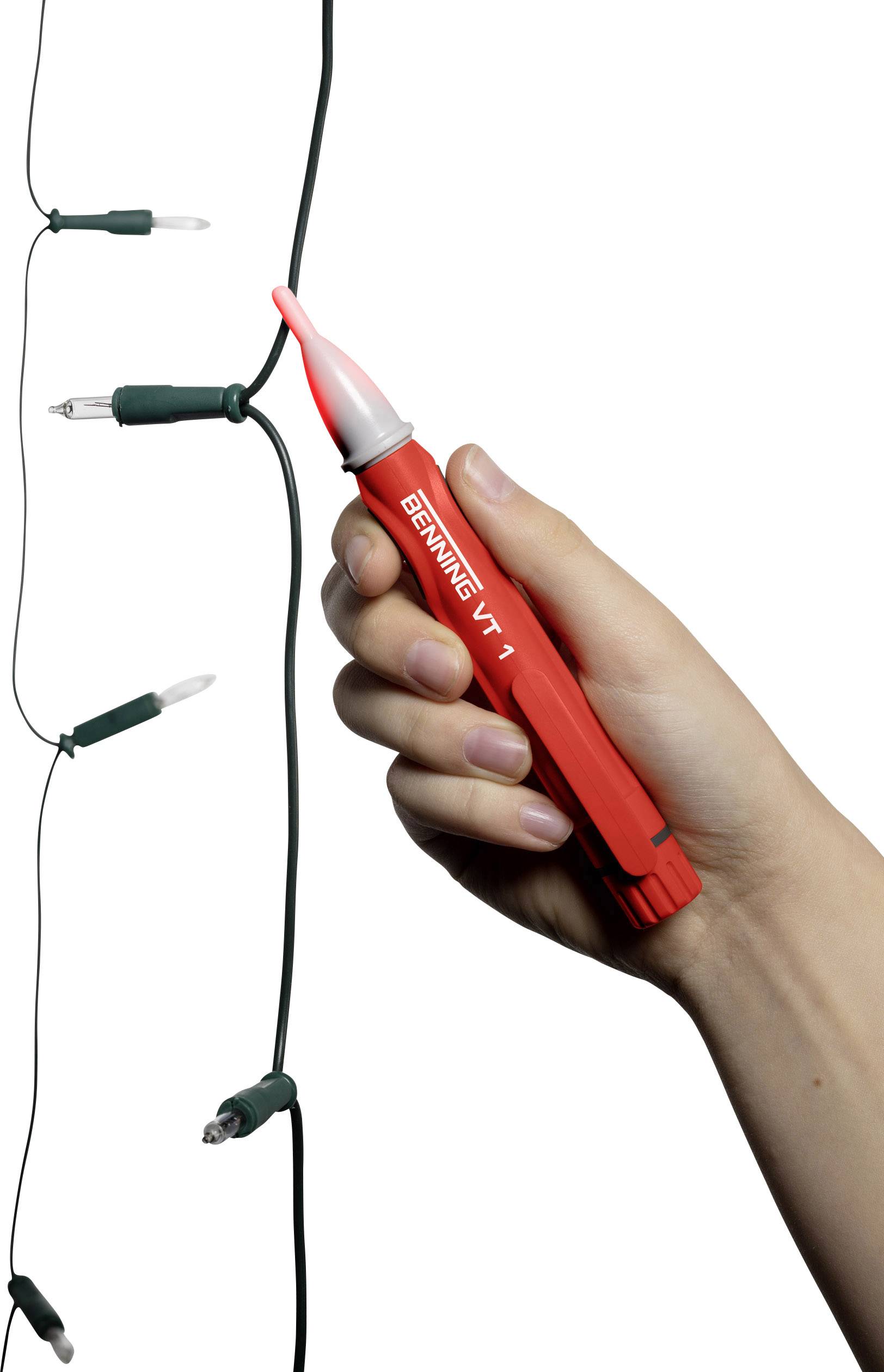 Eine Hand hält einen Spannungsprüfer, der leuchtet, um Strom in einer Lichterkette anzuzeigen.