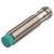 Zylindrischer induktiver Näherungssensor in Metall mit grüner Frontkappe, verwendet zur berührungslosen Erkennung von Objekten.