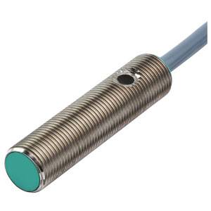 Ein zylindrischer induktiver Sensor mit metallischem Gehäuse und grünem Sensorende. Ein Kabel ist an der Rückseite befestigt.