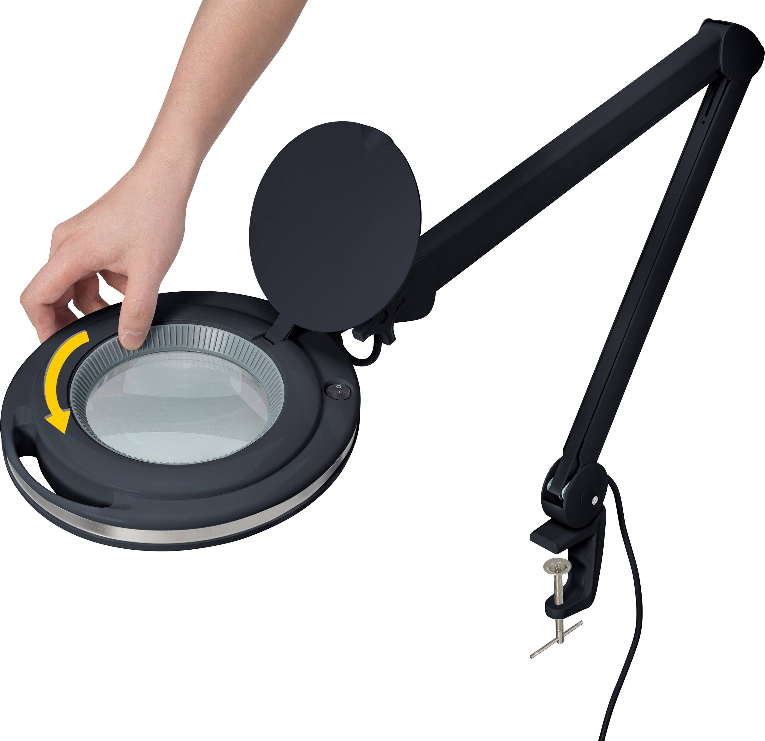 'Hand dreht Abdeckung einer schwarzen, flexiblen Lupenlampe mit rundem Glas. Die Lampe hat einen Schwenkarm und eine Tischklemme.'