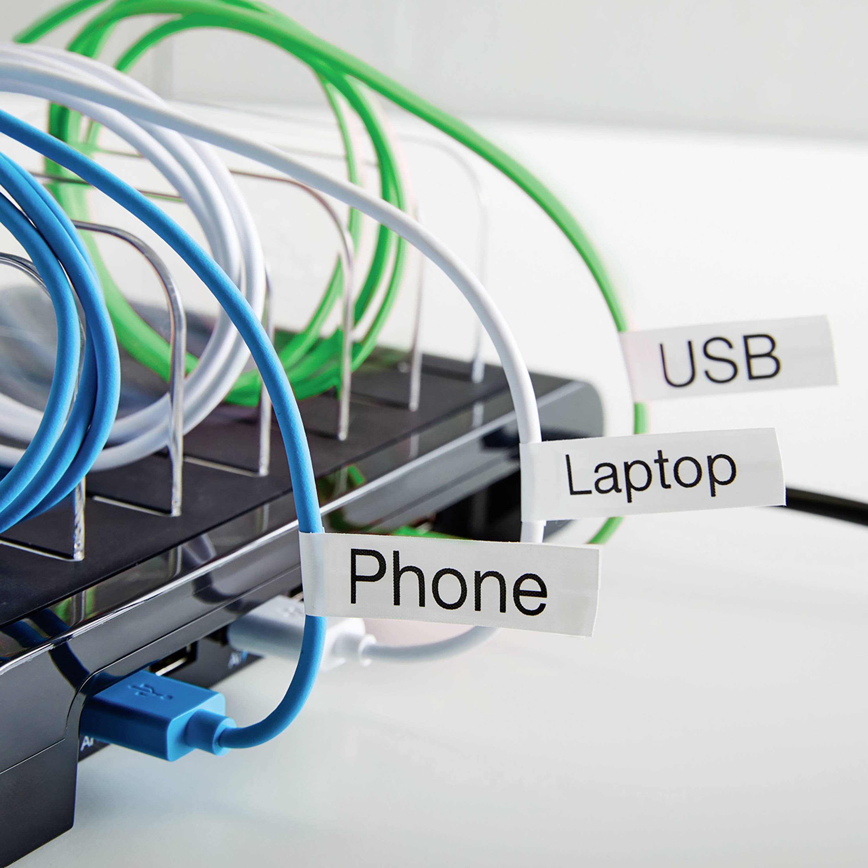 Ein Steckerhalter mit fünf angeschlossenen Kabeln, die mit 'USB', 'Laptop' und 'Phone' beschriftet sind. Kabel sind farblich markiert.