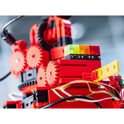 Ein leuchtend roter Roboter mit Zahnrädern und Kabeln. Bunte Steckmodule oben; Technik und Kreativität symbolisierend.