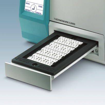 Drucker mit offenem Schubfach zeigt bedruckte Etikettenkarten. Text auf Display: 'Repeat', 'Feed', 'Cancel'.