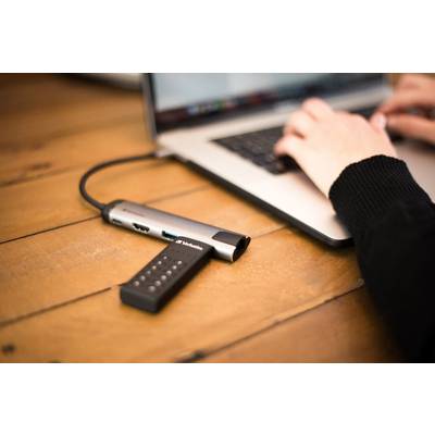 Eine Person tippt auf einem Laptop. Ein USB-Stick ist in einen multifunktionalen USB-Hub gesteckt, der am Laptop angeschlossen ist.