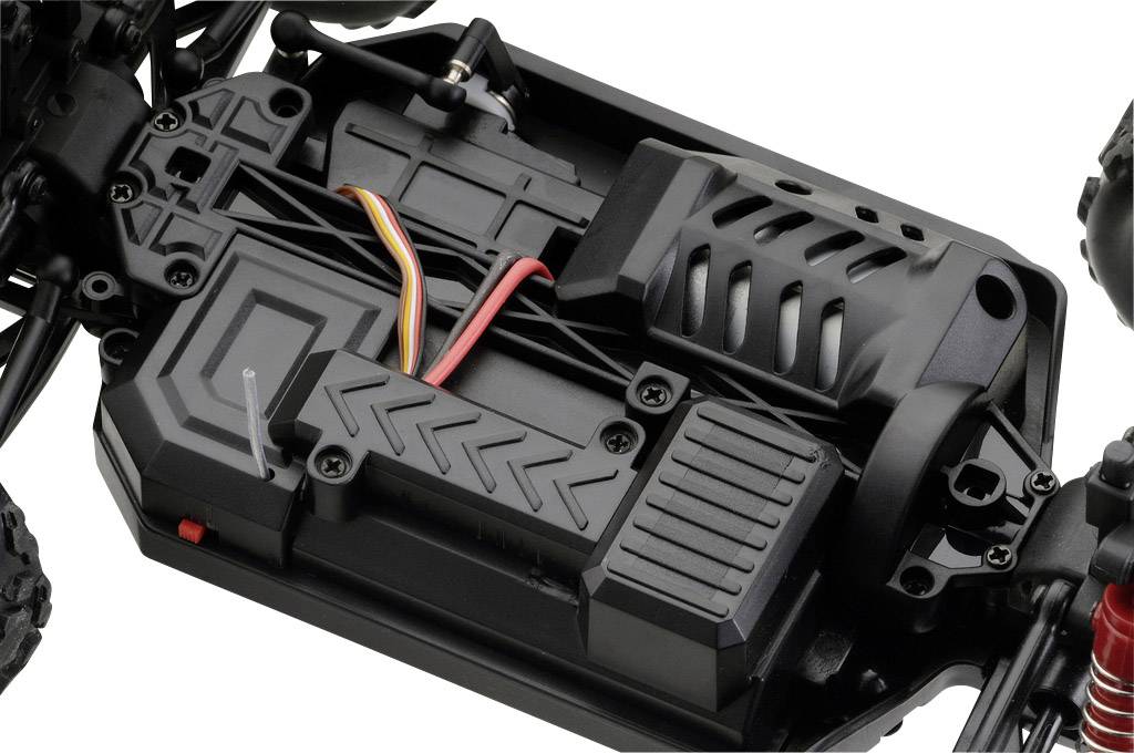 Nahaufnahme eines ferngesteuerten Fahrzeugchassis mit sichtbarer Elektronik, Batteriefächern und Kabeln, auf einem dunklen Untergrund.